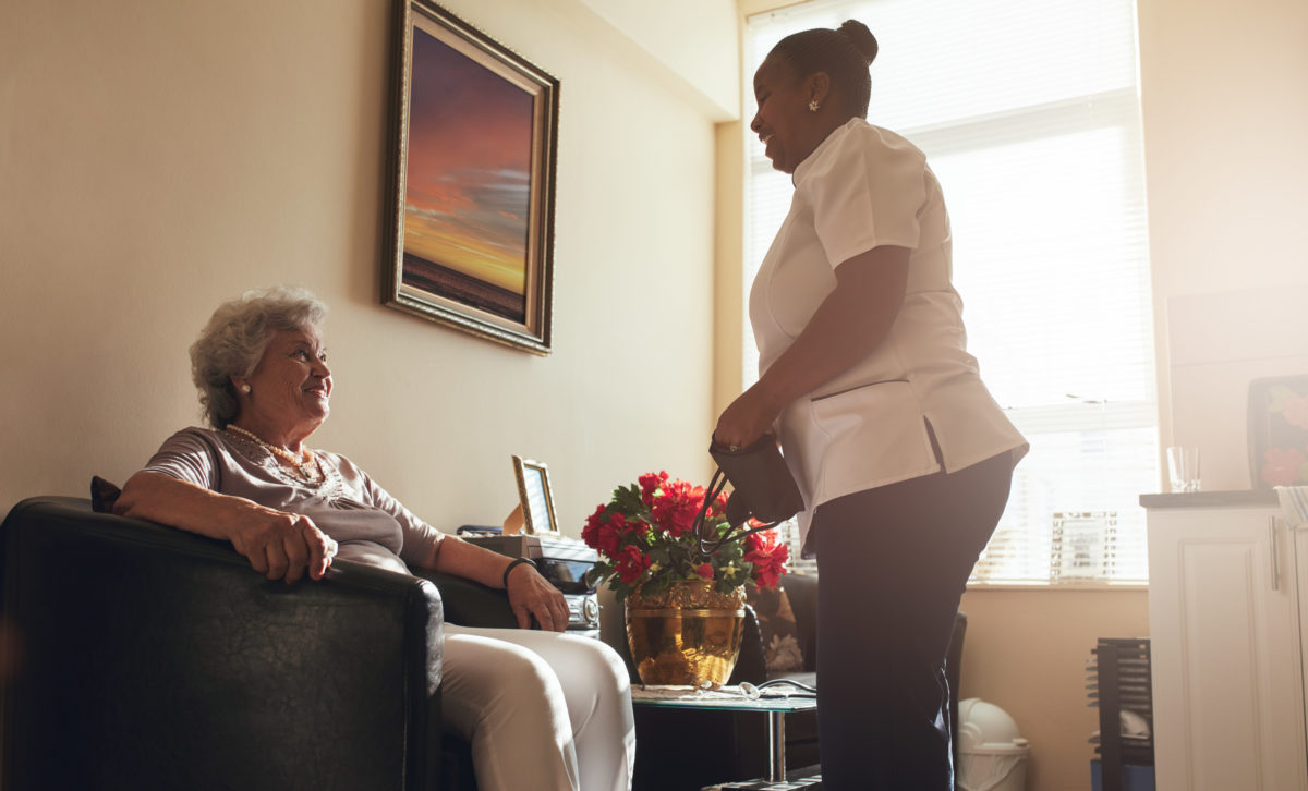 senior-woman-at-home-with-female-caregiver-PQP4YA9