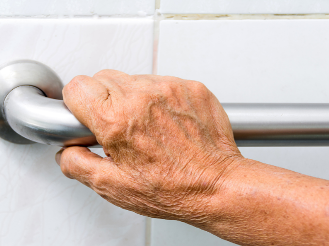 Aging hand on grab bar